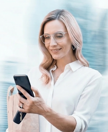 ผู้หญิงสวมแว่นโปรเกรสซีฟใช้งานโทรศัพท์